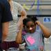 Erickson Elementary School student Aniyah Rivera-Dotson adjusts her silly glasses as she checks out a science display at Cliff Keen Arena during the 14th Annual Kids' Fair at University of Michigan on Friday. Melanie Maxwell I AnnArbor.com